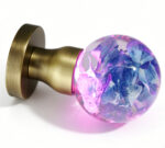 Handcrafted Hydrangea Resin Door Knob Emitting a Pink Glow, Mounted on a Round, Copper-Toned Brass Base