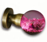 A resin door knob featuring a micro-landscape theme and emitting a red glow, mounted on a round, copper-toned brass base.