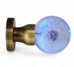 A dandelion-themed resin door knob that emits a blue glow, mounted on a round, copper-toned brass base.