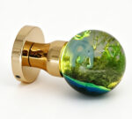 An elephant-themed resin door knob emitting a warm yellow glow, mounted on a round gold-tone brass base.