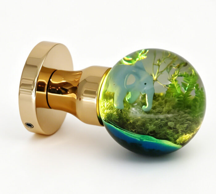An elephant-themed resin door handle with a warm yellow light. An elephant-themed resin door knob emitting a warm yellow glow, mounted on a round gold-tone brass base.
